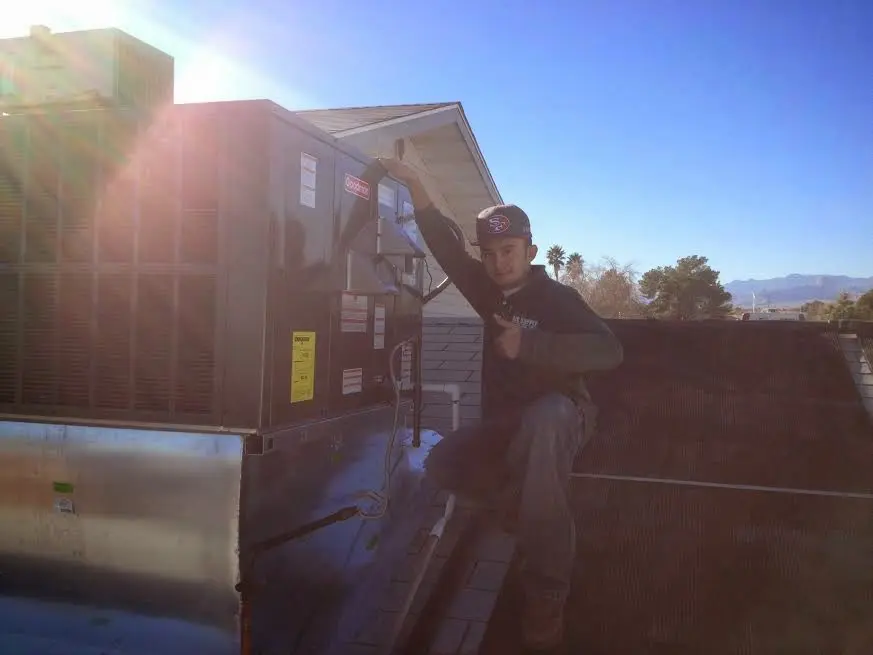 HVAC technician performing Heat Pump Repair on a rooftop unit in Fernley
